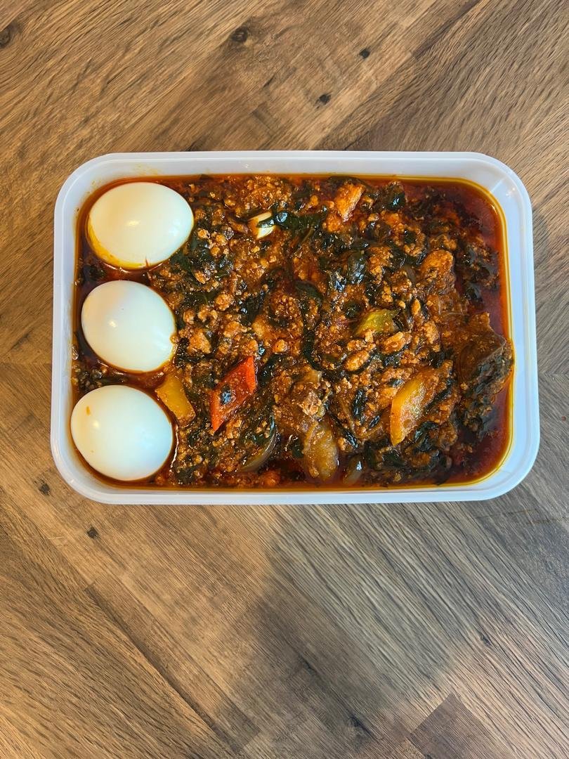 Egusi and spinach stew topped with boiled egg